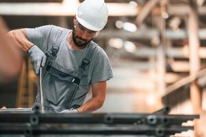 Handsome man. Young factory worker in grey uniform photo