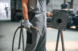 Holding welding equipment. Close up ,,view of man that is working at the factory photo