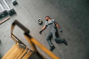 Accident, male, factory worker, fell, without consciousness, lying down on the floor photo