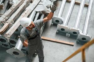 Making ,gesture by hands. Young factory worker in grey uniform photo