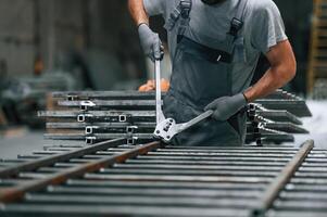 Using ,the, clippers to cut the metal product. Close up view of man that is working at the factory photo