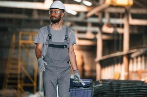 Front ,view, walking, forward. Young factory worker in grey uniform photo