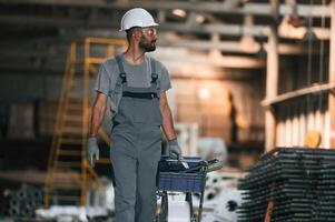 Front, view, walking, forward.. Young factory worker in grey uniform photo