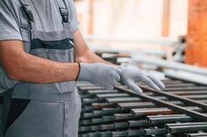 Wearing the gloves. Close up view of man that is working at the factory photo