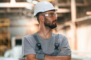 Handsome man... Young, factory worker in grey uniform photo