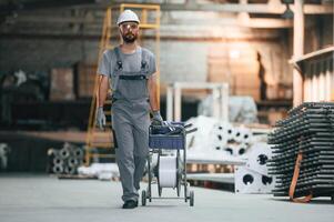 Front ,view, walking forward. Young factory worker in grey uniform photo