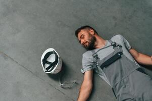 Accident,, male factory worker fell, without consciousness, lying down on the floor photo