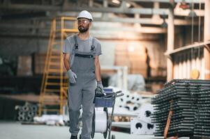 Front, view, walking, forward. Young factory worker in grey uniform photo