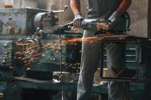 Polishing, the, surface with angle, grinder.. Close up view of man that is working at the factory photo