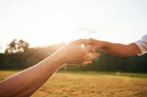 Beautiful sunlight. Close, up ,view ,of ,dad and his little son hands that are holding each other photo