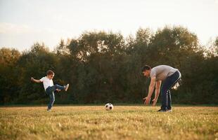 Conception of soccer game. ,Father, and little son are playing and having fun outdoors photo