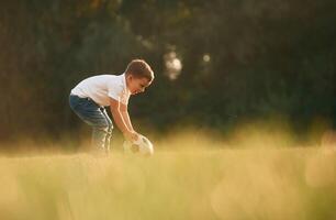 Side, view, playing, soccer.. Little boy is playing outdoors at daytime photo