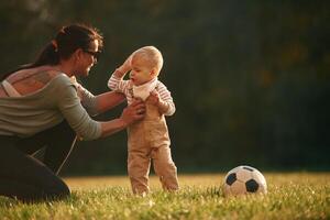 On the field. Mother is with her little baby son are outdoors together photo