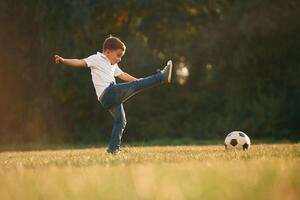 Side, view, playing, soccer. Little boy is playing outdoors at daytime photo