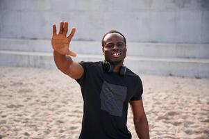 Greeting ,hand. Handsome, black man is posing outdoors at daytime photo