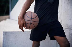 Close up view. Young black man is with baske,tball ball outdoors photo
