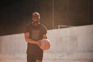 Holding, ball in hands. Young black man photo