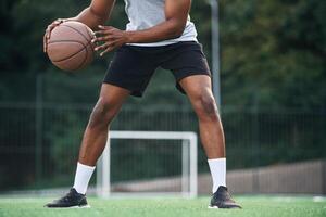Close up ,view. Young black man is with basketball ball outdoors photo