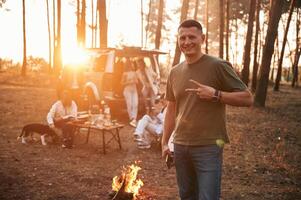 Happy, man ,is smiling. Group of friends are together in the forest photo