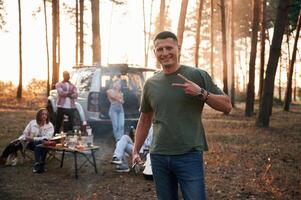 Happy man is smiling. .Group of friends are together in the forest photo