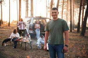 Happy man,, is smiling. Group of friends are together in the forest photo