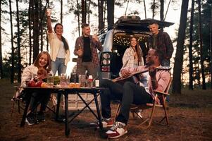 Evening, time,,, by the table. Group of friends are together in the forest photo