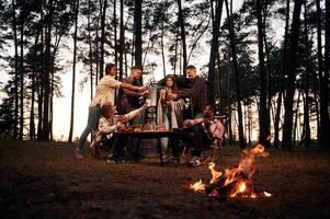 Beautiful, ,bonfire ,at evening time. Group of friends are together in the forest photo
