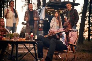 By, the, table at evening time. Group of friends are together in the forest photo