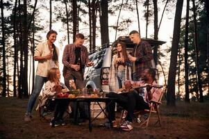 Evening ,time, by the table. Group of friends are together in the forest photo