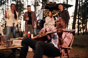 Acoustic, guitar, player. Group ,,of friends are together in the forest photo