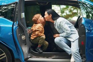 Mothe,r with her little son are in the modern car, having fun photo