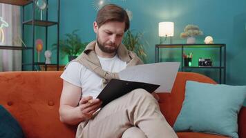 Young man freelancer work with documents from home, analyzing information prepare financial report video