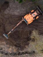 Aerial View of Construction Vehicle on Disturbed Soil with Sparse Vegetation photo