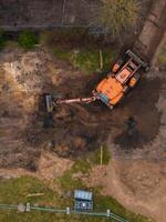 Aerial View of Excavator Operating on Construction Site with Soil and Grass photo