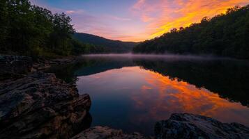 A beautiful sunrise over a river with rocks and trees photo