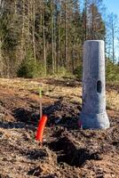 Construction Site with Light Pole Base and Forest Background photo