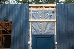 Partially Constructed House with Blue Cladding and Ventilation System photo