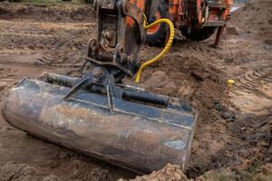 Excavator Bucket in Action on Active Construction Site photo