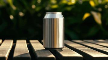 Blank silver soda can with condensation placed on wooden surface outdoors with green foliage background in natural summer lighting for branding use photo