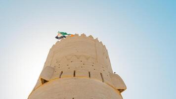 A tall tower with a flag flying from it photo