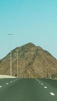 An empty highway with a mountain in the background photo