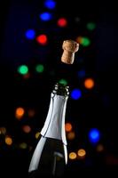 Celebrate the moment with champagne cork popping against festive bokeh lights photo
