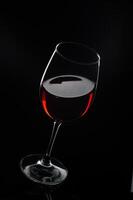 Elegant red wine glass showcasing a rich, deep hue against a dark backdrop, inviting taste and indulgence in every sip photo