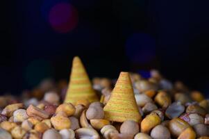 Colorful conical treats surrounded by a variety of vibrant nuts and seeds in a festive atmosphere photo