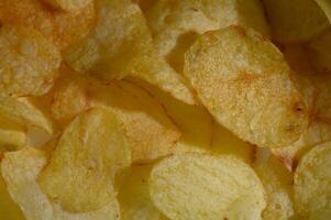 Golden, crispy potato chips arranged in a tempting display ready for snacking during a movie night at home photo