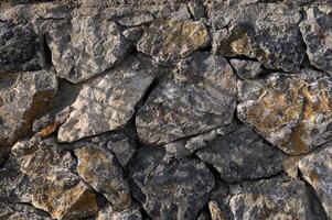 Natural stone wall showcases rugged textures and earthy tones for an organic feel in architectural design photo