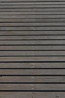 Rustic wooden planks form a tranquil path alongside a shimmering lake at dusk photo
