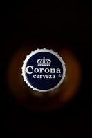 Gaziveren Cyprus -24.03.2025 Refreshing moments captured with a close-up of a Corona beer bottle cap shimmering under soft light in a cozy setting during the evening hours photo