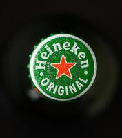Gaziveren Cyprus -24.03.2025 heineken beer Refreshing drink topped with a bright green bottle cap showcasing a classic star emblem in a cozy gathering setting photo