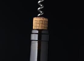 Corkscrew emerges from a wine bottle, highlighting the anticipation of an elegant evening gathering in a cozy setting photo